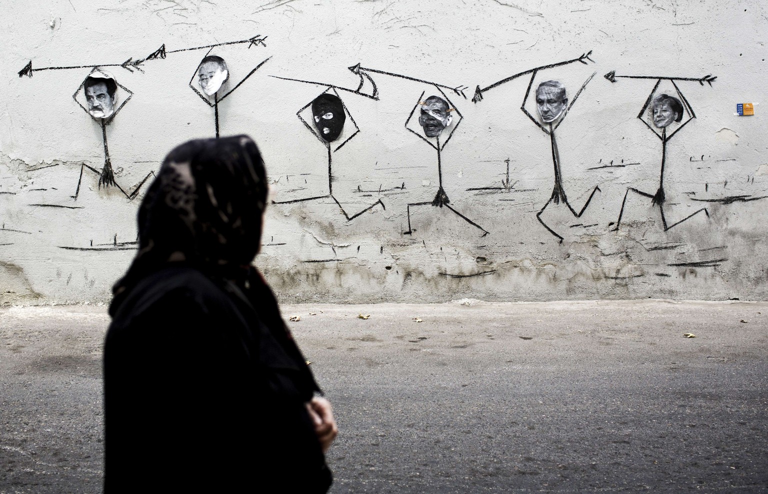 Niemand von ihnen stoppt die Gewalt in Gaza. Sie sind mitschuldig, findet diese Streetartist im Iran: Saddam Hussein, Ban Ki-moon, ein Maskierter, Barack Obama, Benjamin Netanyahu und Angela Merkel.