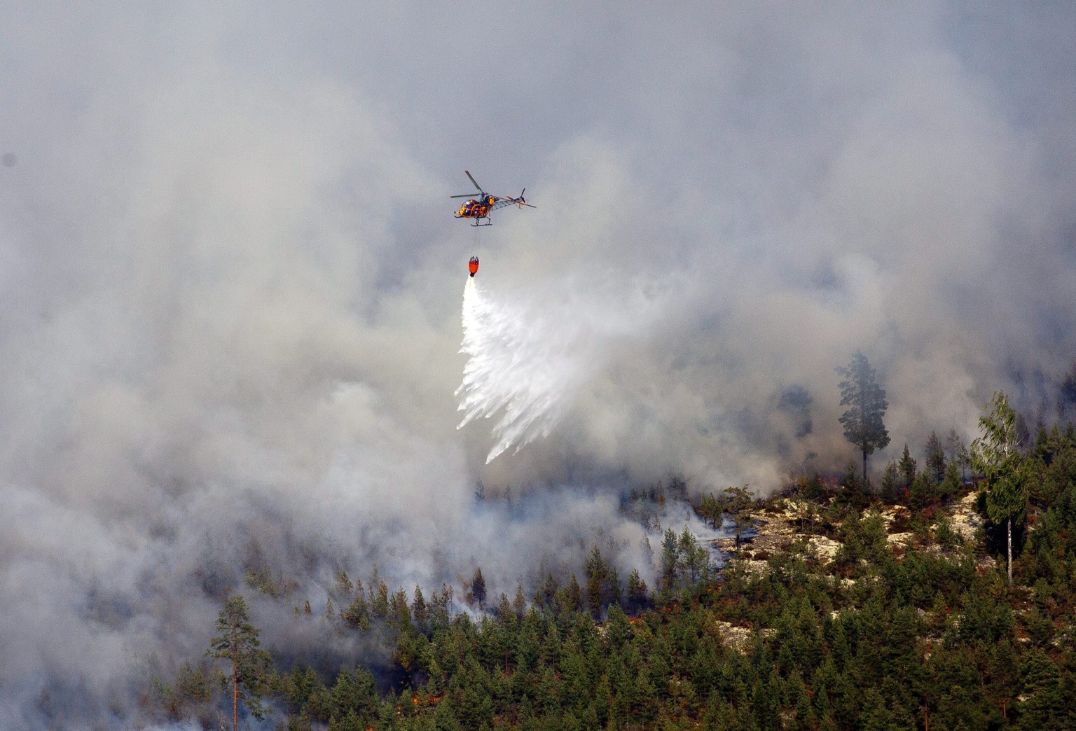 Ein Helikopter dämmt den Waldbrand in der Nähe der schwedischen Ortschaft Sala ein. Die Einsatzkräfte rechnen damit, dass der Brand noch Tage, vielleicht sogar Wochen, anhalten wird.