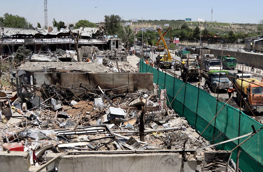 epa06002728 Workers remove debris from a damaged area a day after a suicide bomb attack near foreign embassies in Kabul, Afghanistan, 01 June 2017. At least 90 people were killed and more than 350 wer ...