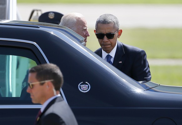 President Barack Obama and Vice President Joe Biden talk outside the presidents limousine before taking off from Love Field Airport, Tuesday, July 12, 2016, in Dallas. Obama and Biden attended the mem ...