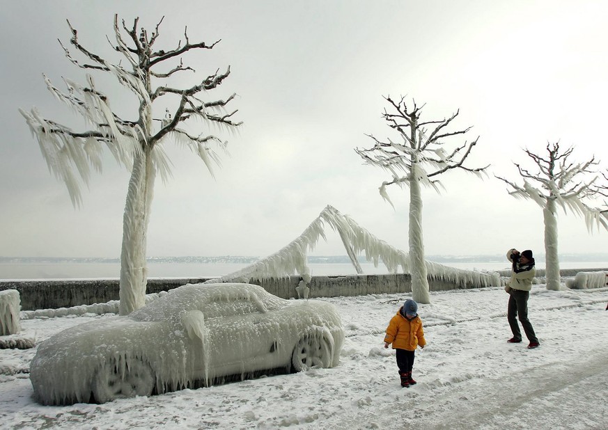 JAHRESRUECKBLICK 2005 - INLAND - SCHWEIZ VERSOIX WINTER: People admire ice-covered cars, light garlands and trees at the shores of lake Geneva near Versoix, Switzerland, Friday, January 28, 2005. Stro ...