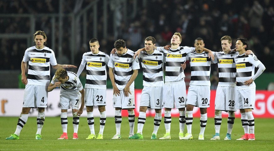 Borussia&#039;s players stand on the pitch during the penalty shootout of the German Soccer Cup semifinal match between Borussia Moenchengladbach and Eintracht Frankfurt in Moenchengladbach, Germany,  ...