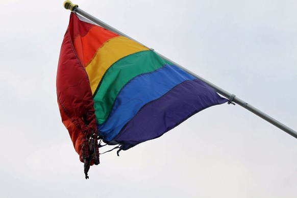 A partially burned flag hangs outside the Identity Inc.&#039;s Gay and Lesbian Community Center on Weds., June 24, 2015, in downtown Anchorage, Alaska. Identity Inc. Executive Director Drew Phoenix sa ...