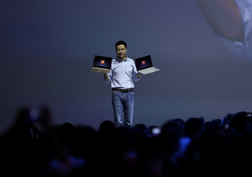 Lei Jun, founder and CEO of China&#039;s mobile company Xiaomi, gestures as he holds Mi Notebook Air during a launch of the company&#039;s new products in Beijing, China, July 27, 2016. REUTERS/String ...
