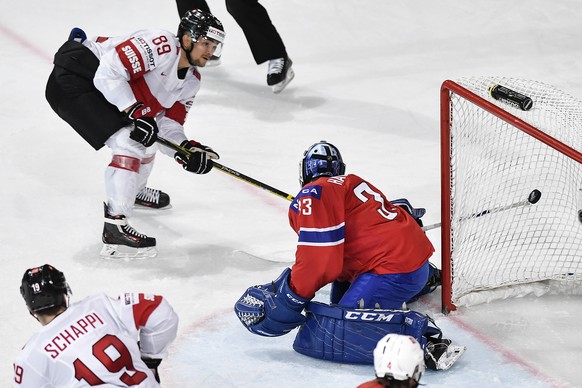 Switzerland’s Cody Almond, left, scores to 2:0 against Norway’s goaltender Henrik Haukeland during their Ice Hockey World Championship group B preliminary round match between Switzerland and Norway in ...