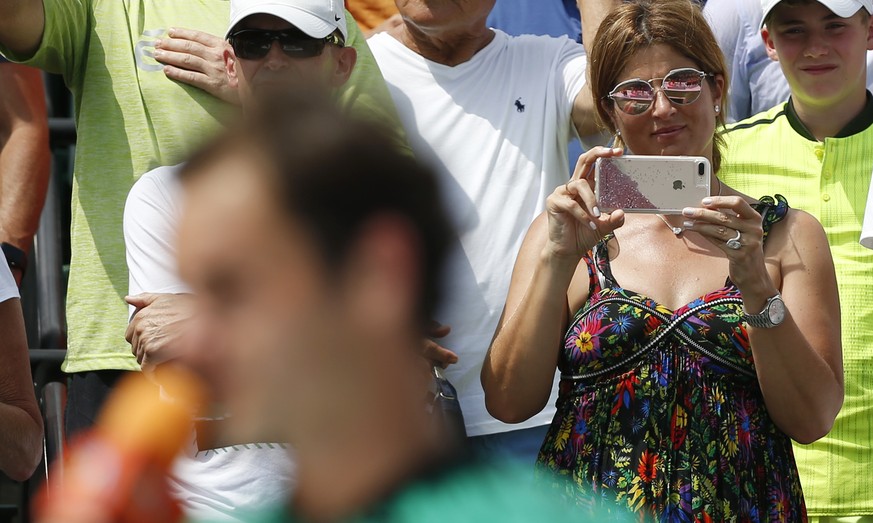 Mirka Federer, rear, wife of Roger Federer, of Switzerland, uses her phone to take photos of him after he defeated Rafael Nadal, of Spain, during the men&#039;s singles final tennis match at the Miami ...