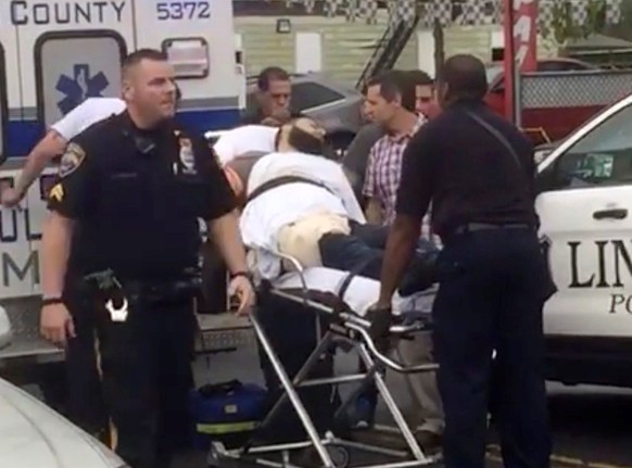 Policemen place in an ambulance a man they identified as Ahmad Khan Rahami, who is wanted for questioning in connection with an explosion in New York City, in Linden, New Jersey, in this still image t ...