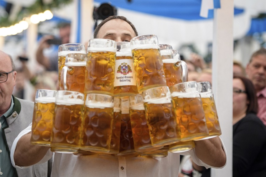 Oliver Struempfel competes during his world record attempt, carrying 27 beer mugs at the traditional festival Gillamoos in Abensberg, Germany, Sunday, Sept. 3, 2017. He succeeded. (Matthias Balk/dpa v ...