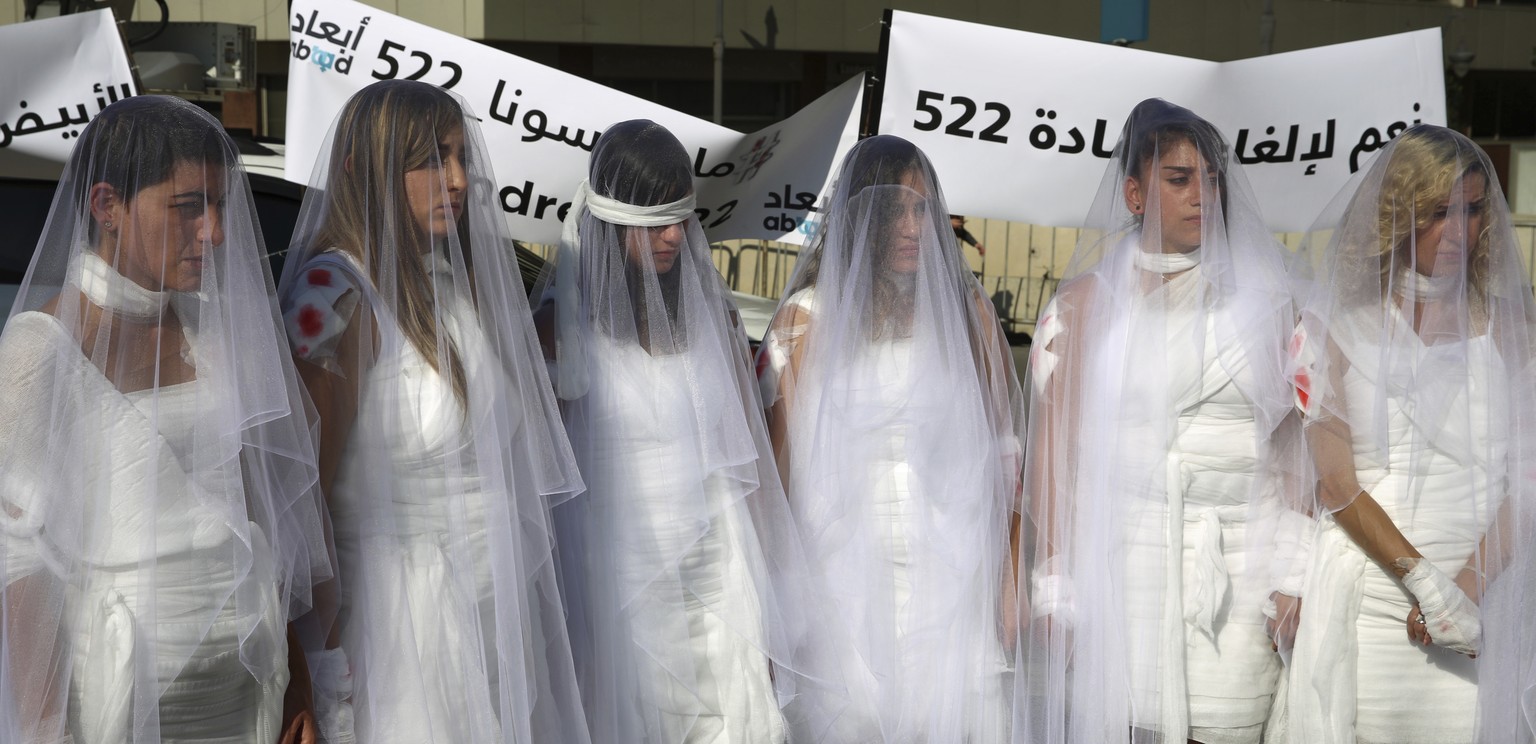 FILE -- In this December 6, 2016 file photo, Lebanese women, dressed as brides in white wedding dresses stained with fake blood, protest against article 522 in the Lebanese penal code that stipulates  ...