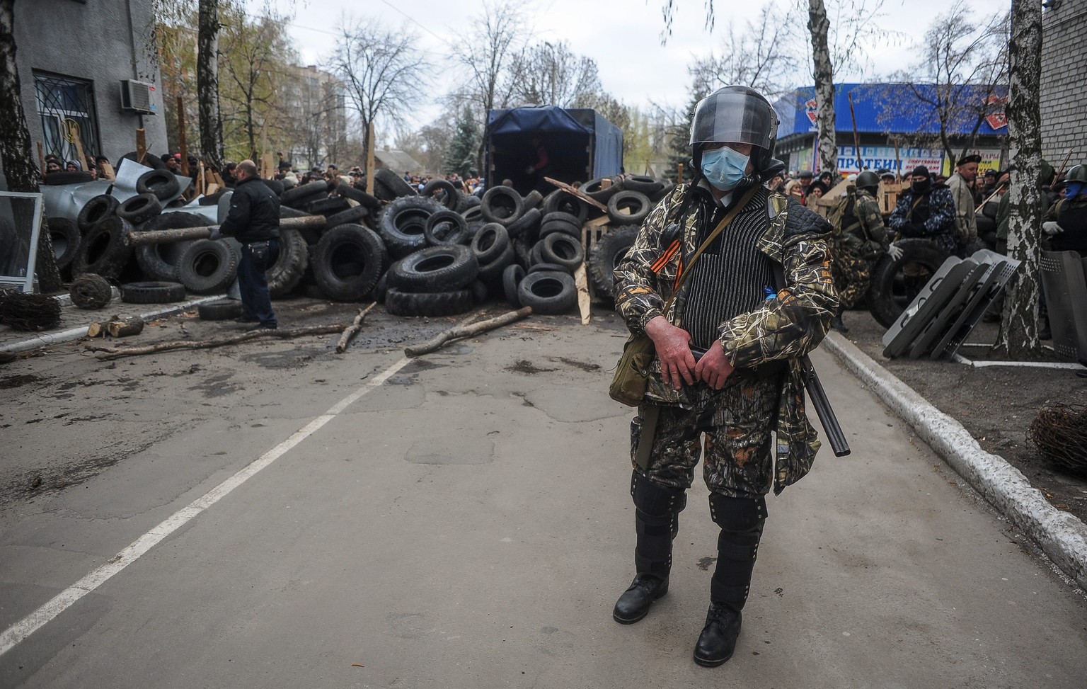 Bewaffnete haben vor der eingenommenen Polizeistation in Slawjansk Barrikaden errichtet.