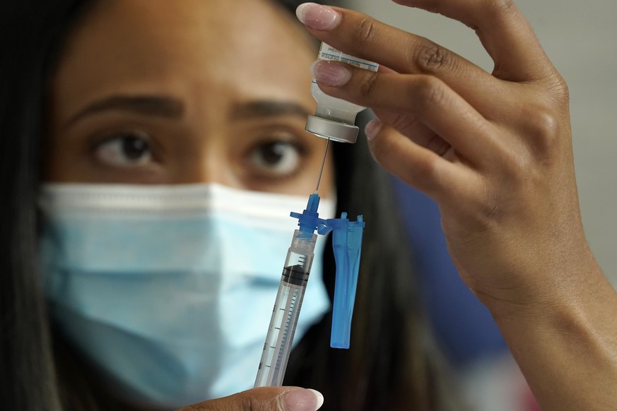 FILE - In this Wednesday, May 19, 2021 file photo, a licensed practical nurse draws a Moderna COVID-19 vaccine into a syringe at a mass vaccination clinic at Gillette Stadium in Foxborough, Mass. On W ...