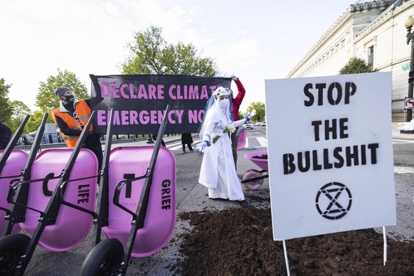 epa09152712 Climate activists with Extinction Rebellion DC leave a pile of manure on 17th Street near the White House to protest US President Joe Biden&#039;s plan to cut US emissions in half by 2030, ...