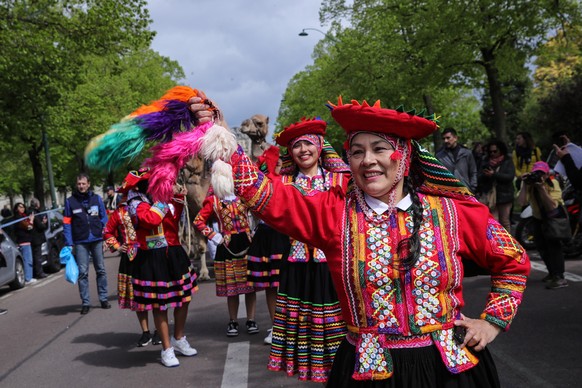 epa11290176 People in typical Peruvian costumes perform traditional dances during the Camel Parade through Vincennes forest in Vincennes, France, 20 April 2024. The FFDCFE (French Federation for the D ...