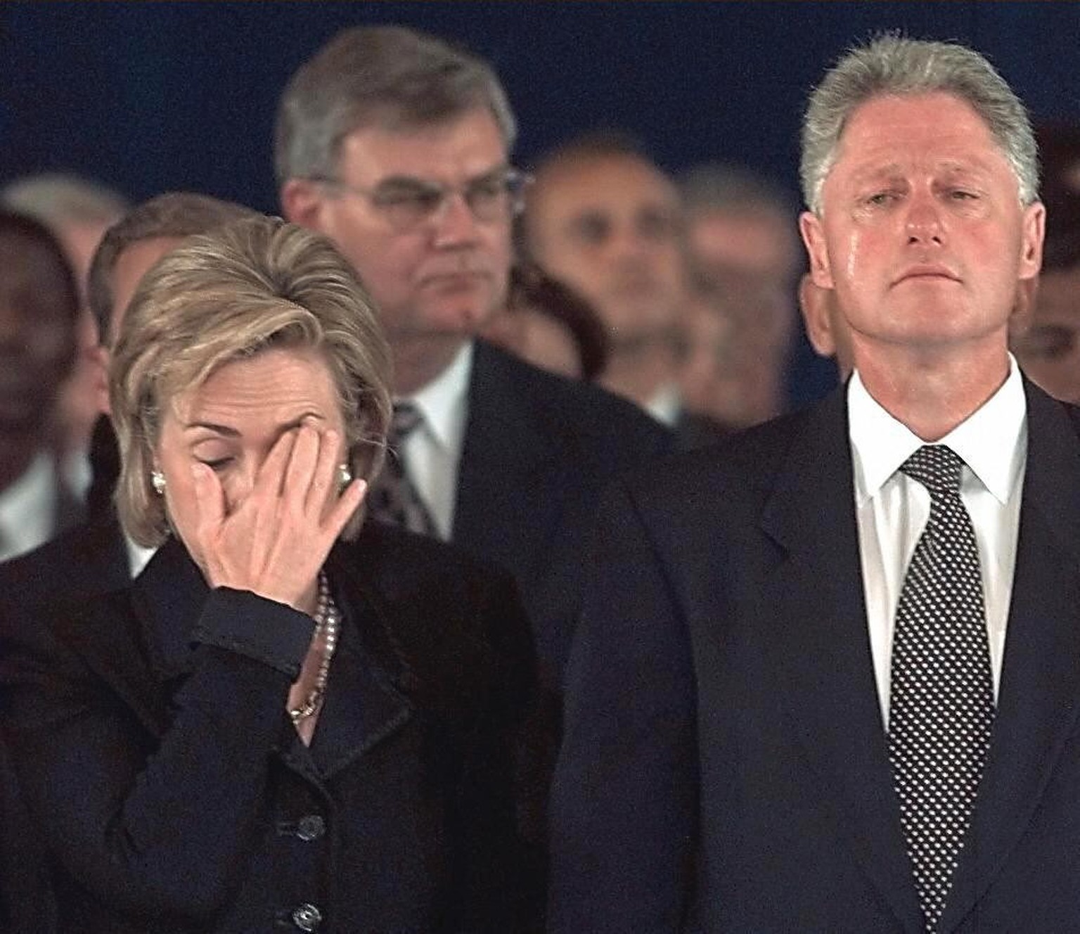 US President Bill Clinton (right) and his wife Hillary stand teary-eyed during ceremonies on August 13, 1998, at Andrews Air Force Base in Maryland. The Clintons attended services for the victims of t ...