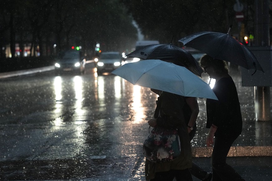 epa13270227 Pedestrians holding umbrellas cross a street during heavy rain in Barcelona, Spain, 29 September 2026. Spain's State Meteorological Agency (AEMET) has issued weather warnings for seve ...