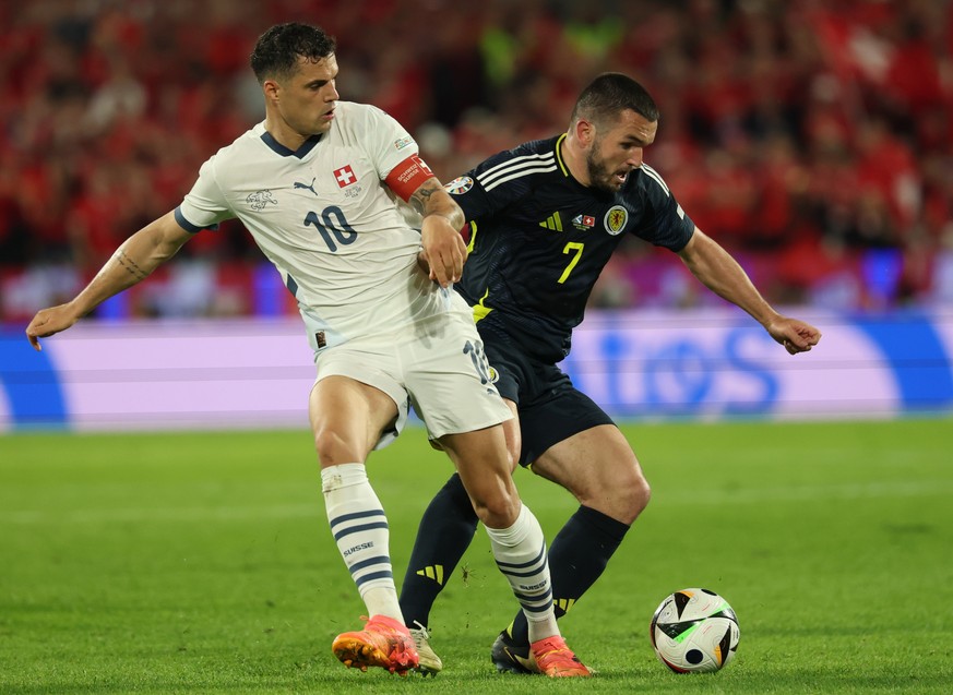 epa11424120 Granit Xhaka (L) of Switzerland in action against John McGinn of Scotland during the UEFA EURO 2024 group A soccer match between Scotland and Switzerland, in Cologne, Germany, 19 June 2024 ...