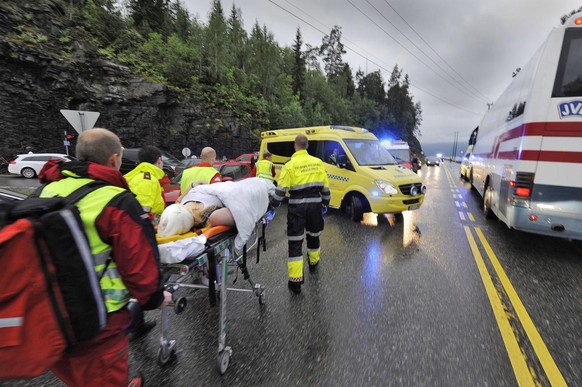 epa02837453 Norwegian rescue personnel take away an injured person that was brought ashore from a camp site at Utoya island near Oslo, early 23 July 2011. At least 84 people were killed in a shooting  ...