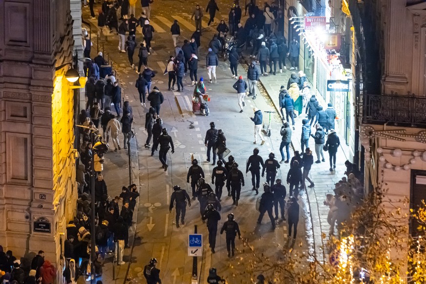 Les forces de police françaises affrontent des supporters qui célèbrent la victoire de la France face au Maroc au Qatar.