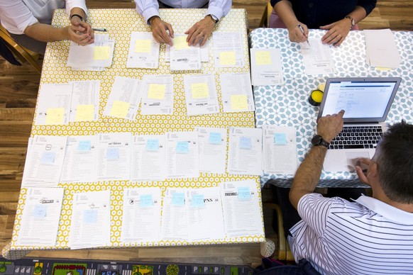 Des personnes effectuent le depouillement de bulletin de vote et les inscrivent dans le systeme electronique votelec lors des resultats des elections federales ce dimanche 20 octobre 2019 a Daillens,  ...