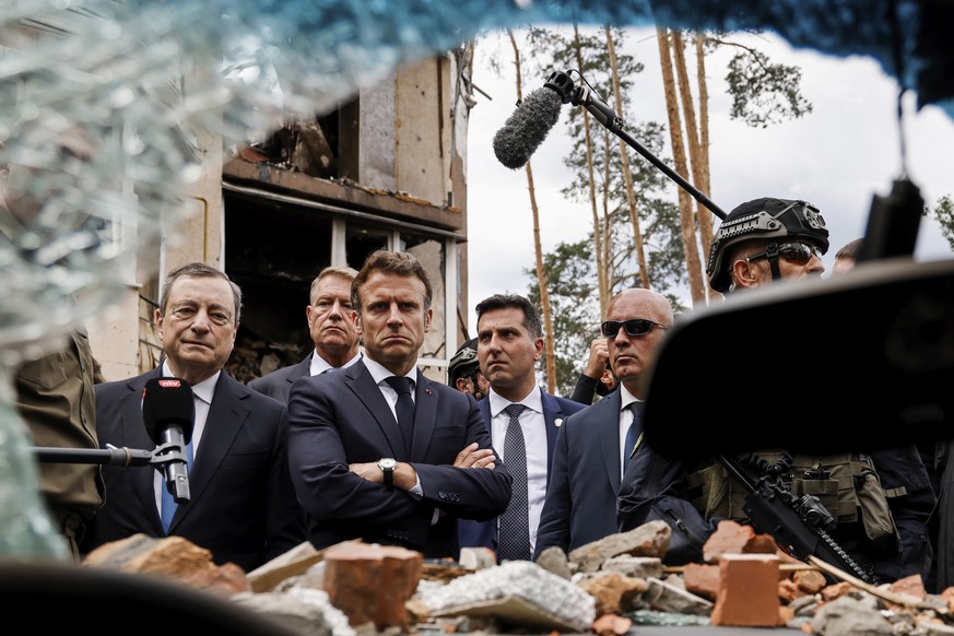 FILE - Italian Prime Minister Mario Draghi, left, and French President Emmanuel Macron examine debris as they visit Irpin, outside Kyiv, Ukraine, Thursday, June 16, 2022. The leaders of France, German ...