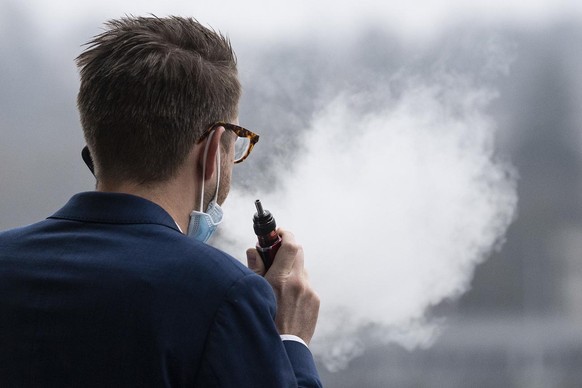 Nationalrat Babtiste Hurni, SP-NE, raucht auf der Terasse eine E-Zigarette an der Wintersession der Eidgenoessischen Raete, am Montag, 7. Dezember 2020, in Bern. (KEYSTONE/Peter Schneider)