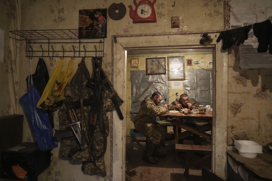 Ukrainian servicemen eat dinner after their duty at the frontline near Svitlodarsk, eastern Ukraine, Wednesday, Feb. 23, 2022. U.S. President Joe Biden announced the U.S. was ordering heavy financial  ...