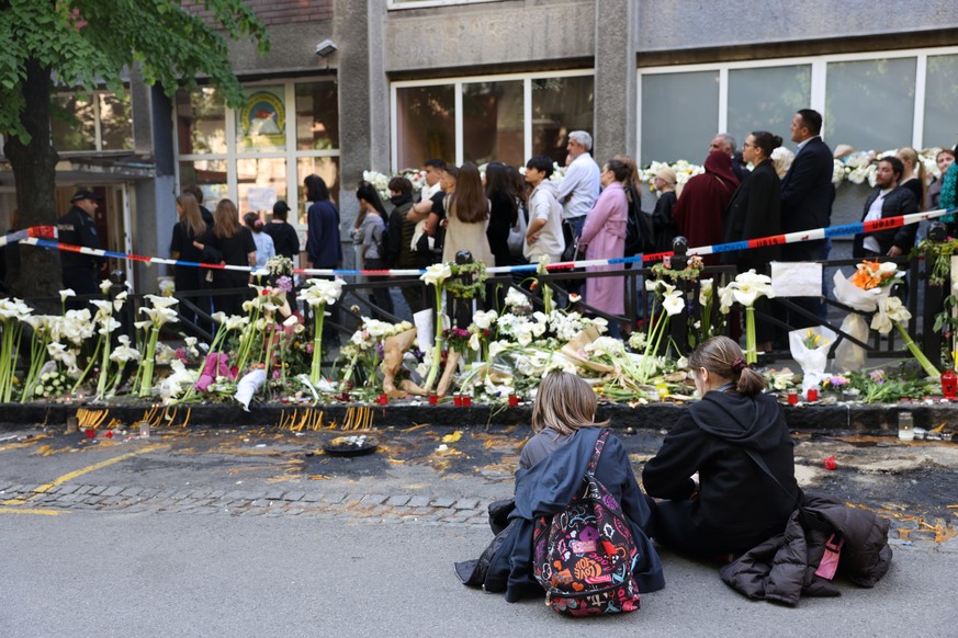 Des élèves assises sur le trottoir, devant l'école élémentaire Vladislav Ribnikar à Belgrade.