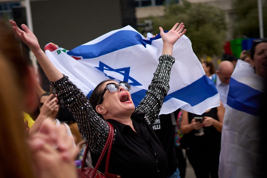 People react as they celebrate following the announcement that Israel and Hamas have agreed to the first phase of a peace plan to pause the fighting, at a plaza known as hostages square in Tel Aviv, I ...
