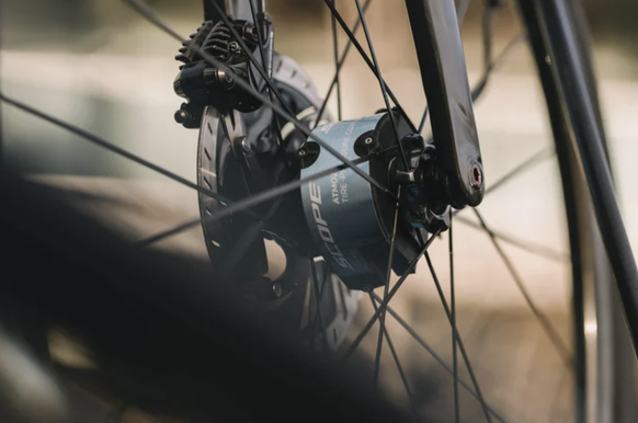Une capsule métallique, installée au centre de la roue, contient une réserve d’air reliée à un pneu tubeless via un fin tuyau.