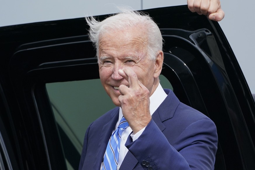 President Joe Biden crosses his fingers as he responds to a question about the short term debt deal as he arrives Air Force One at O'Hare International Airport in Chicago, Thursday, Oct. 7, 2021. ...