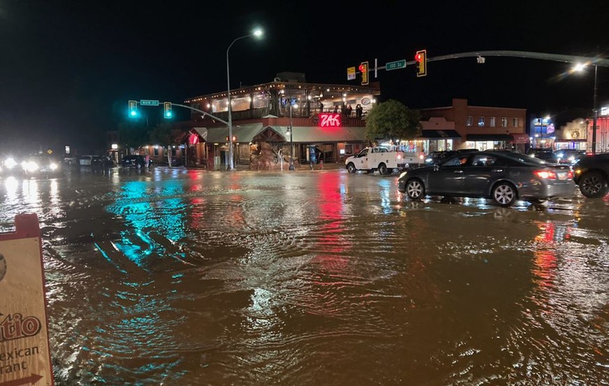 In this photo courtesy of City of Moab, vehicles navigate high waters at the intersection of South Main Street and 100 South in Moab, Utah on Saturday, Aug. 20, 2022. Nearly an inch of rain fell in th ...