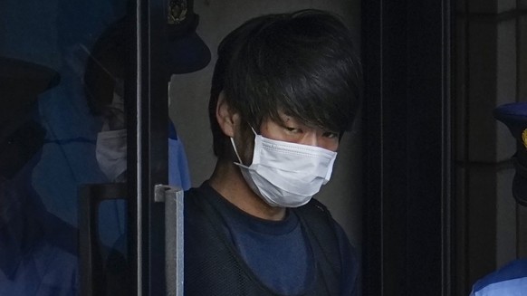 FILE - Tetsuya Yamagami, the alleged assassin of former Japanese Prime Minister Shinzo Abe, gets out of a police station in Nara, western Japan, on July 10, 2022, on his way to local prosecutors' ...