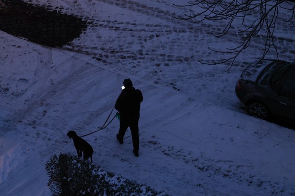 epa12623543 A pedestrian walks through the Lichterfelde district in western Berlin, Germany, 03 January 2026. A major power outage struck western Berlin early 03 January after a cable bridge over the  ...