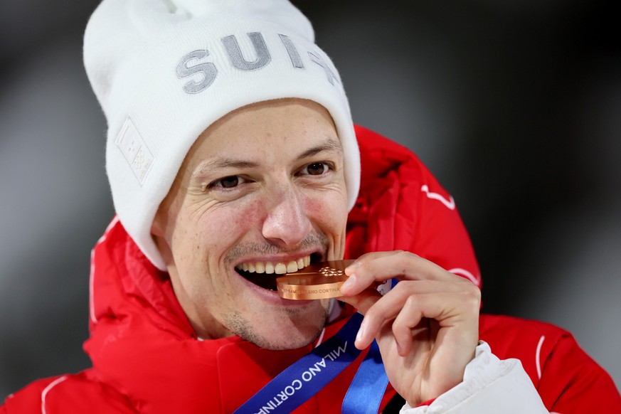 epa12721572 Bronze medalist Gregor Deschwanden of Switzerland celebrates on podium after the Men's Normal Hill of the Ski Jumping competitions at the Milano Cortina 2026 Winter Olympic Games, in  ...