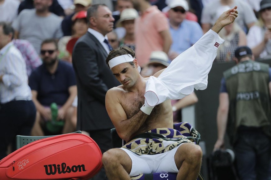 Switzerland&#039;s Roger Federer changes his t-shirt during his men&#039;s singles match against to Germany&#039;s Jan-Lennard Struff, on the fifth day of the Wimbledon Tennis Championships in London, ...