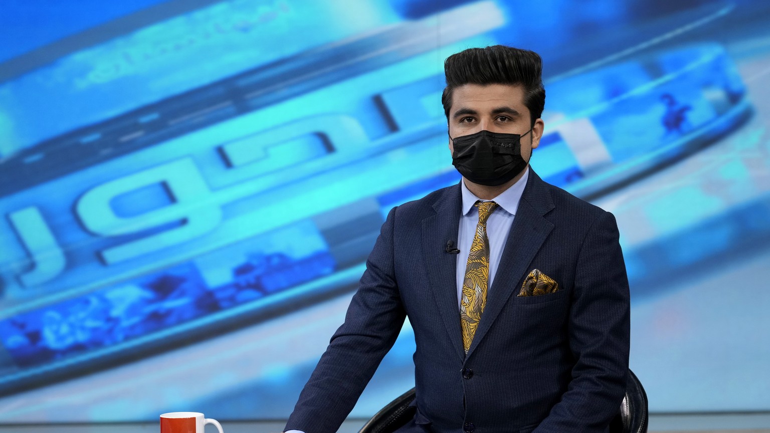 TV anchor Nesar Nabil wears a face mask to protest the Taliban&#039;s new order that female presenters cover their faces, as he reads the news on TOLOnews, in Kabul, Afghanistan, Sunday, May 22, 2022. ...