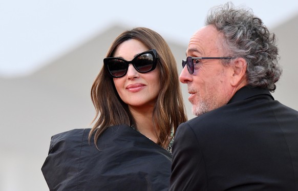 epa11569390 US director Tim Burton (R) and Italian actor Monica Bellucci arrive for the opening ceremony and screening of &#039;Beetlejuice Beetlejuice&#039; at the 81st annual Venice International Fi ...