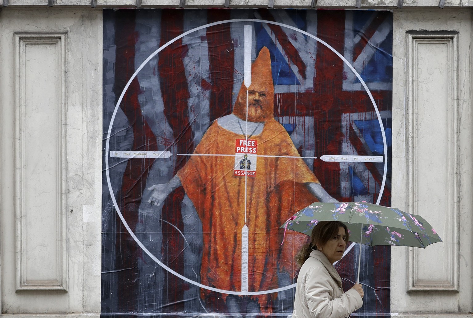 FILE - In this Oct. 21, 2019 file photo a pedestrian passes street art depicting Julian Assange near Westminster Magistrates&#039; Court in London where Assange is expected to appear as he fights extr ...