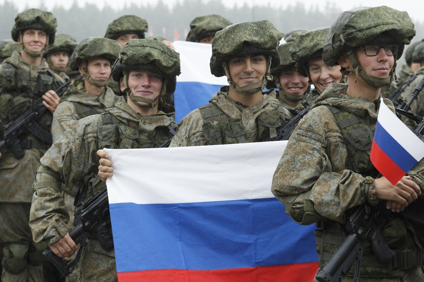 In this photo provided by Russian Defense Ministry Press Service, Russian soldiers hold a Russian national flag as they attend the opening ceremony of the joint strategic exercise of the armed forces  ...