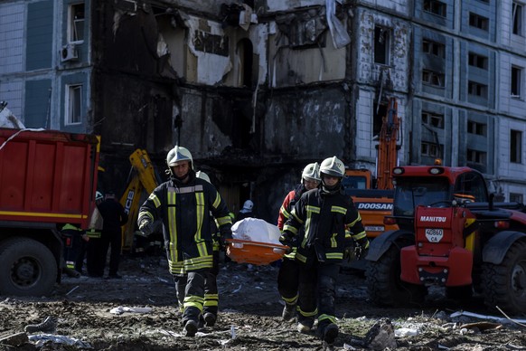 epa10596759 Rescuers carry a body recovered at the site of a damaged residential building after a missile attack, in Uman, Cherkasy region, central Ukraine, 28 April 2023. At least 17 people were kill ...
