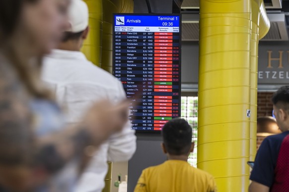 Travellers queue at Geneva Airport, in Geneva, Switzerland, Wednesday, June 15, 2022. After Swiss airspace was closed after a computer glitch with the air traffic control system grounded flights at th ...