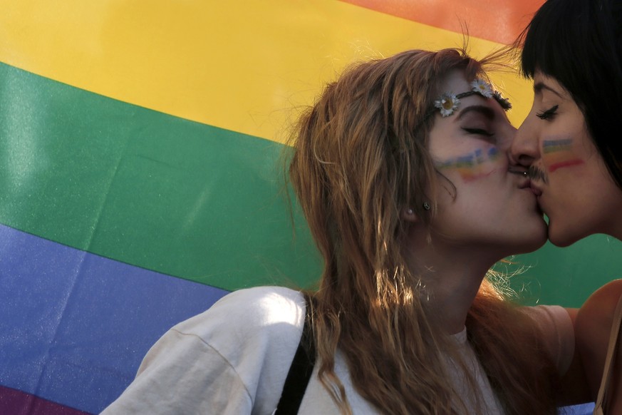 FILE - Two women kiss in front of a rainbow flag, the symbol of the gay rights movement, during the Gay Pride parade in central Athens, Saturday, June 14, 2014. Greece?s center-right government is spe ...