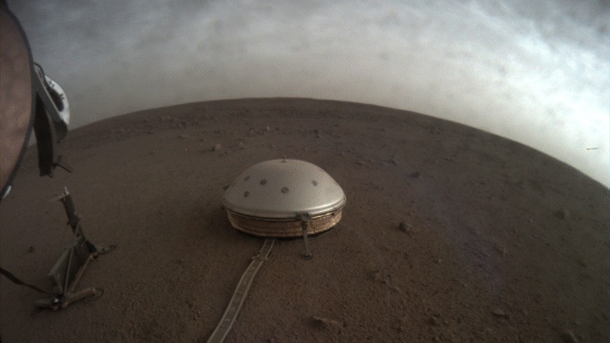 In this undated photo made available by NASA on Thursday, July 22, 2021, clouds drift over the dome-covered SEIS seismometer of the InSight lander on the surface of Mars. The quake-measuring device is ...