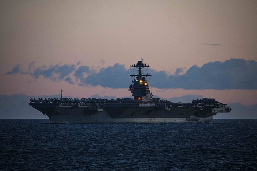 January 5, 2024, Mediterranean Sea, Spain: The U.S. Navy Ford-class aircraft carrier USS Gerald R. Ford transits the Strait of Gibraltar as it departs the Mediterranean Sea at sunset, January 5, 2024  ...
