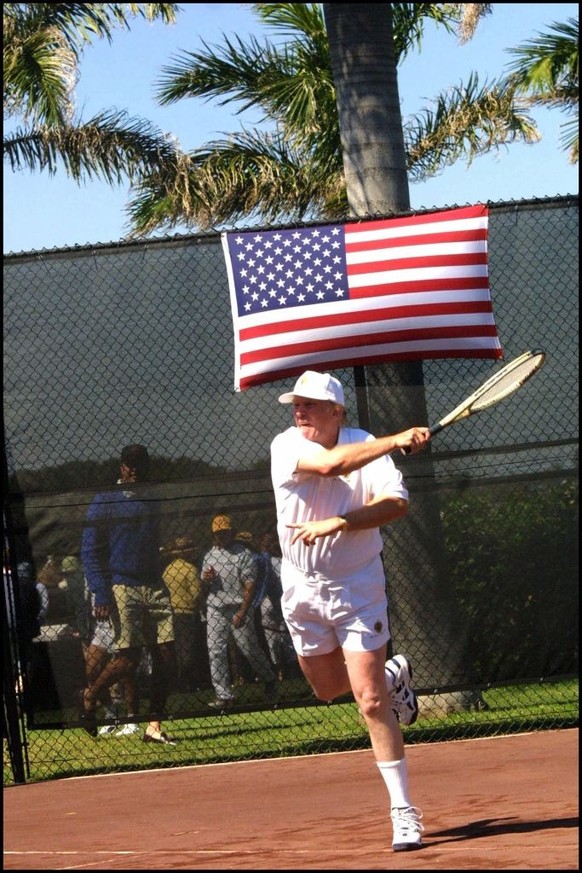 Donald J. Trump blasting a forehand winner from the baseline-with a red, white and blue flag directly over his head. (Photo by Art SEITZ/Gamma-Rapho via Getty Images)