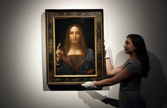 FILE - In this Oct. 24, 2017 file photo, an employee poses with Leonardo da Vinci&amp;#039;s &amp;quot;Salvator Mundi&amp;quot; on display at Christie&amp;#039;s auction rooms in London. Abu Dhabi’s D ...