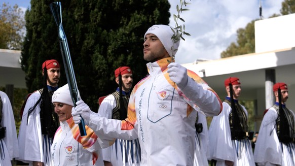 Le rameur grec Petros Gaidatzis (à droite) et la fondeuse italienne Stefania Belmondo ont lancé le relais de la flamme olympique.