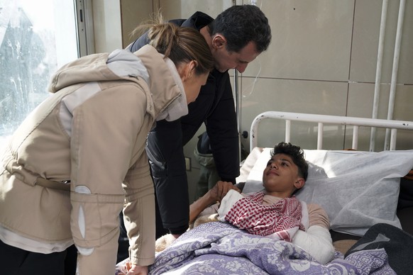 In this photo released by the official Syrian state news agency SANA, Syrian President Bashar Assad, center, and his wife Asma visit a wounded survivor of devastating earthquake, at a hospital in Alep ...