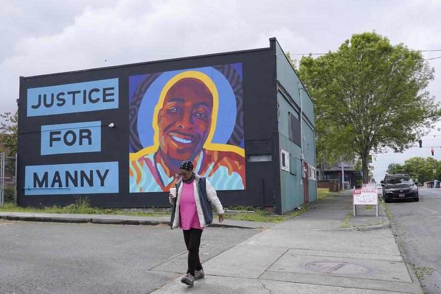 A woman walks past a mural honoring Manuel &quot;Manny&quot; Ellis, Thursday, May 27, 2021, in the Hilltop neighborhood of Tacoma, Wash., south of Seattle. Ellis died on March 3, 2020 after he was res ...
