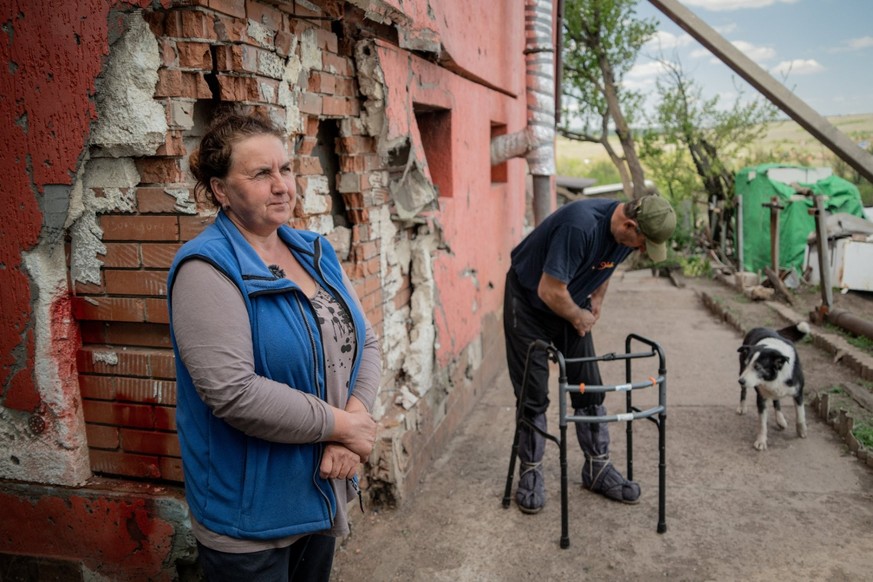 Larisa Sysenko et son mari Viktor Sysenko se tiennent dans la cour de leur maison endommagée dans le village de Kamyanka, dans la région de Kharkiv.